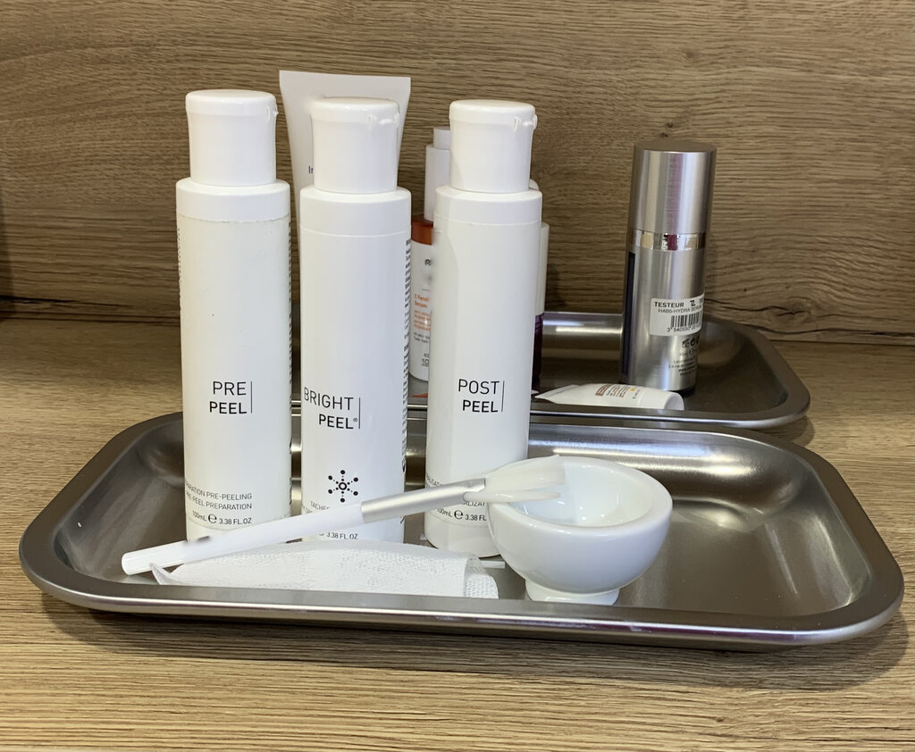 Productos cosméticos profesionales para peelings químicos sobre bandeja de tratamiento facial.