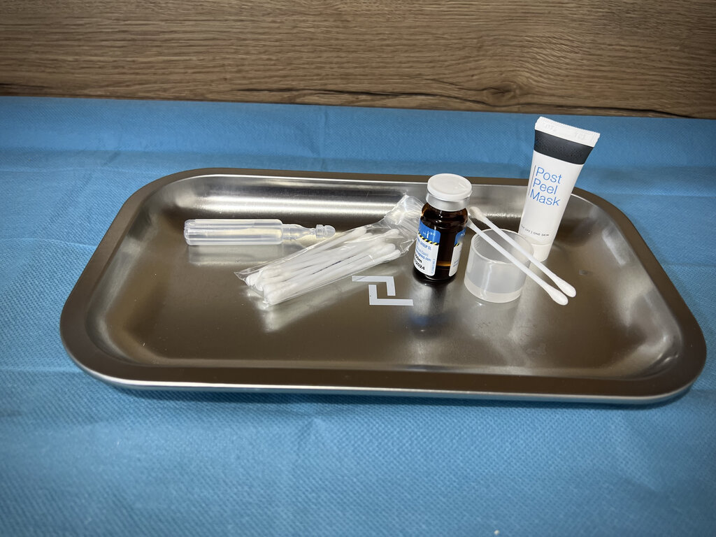 Bandeja con productos cosméticos y utensilios médicos para tratamiento despigmentante facial.